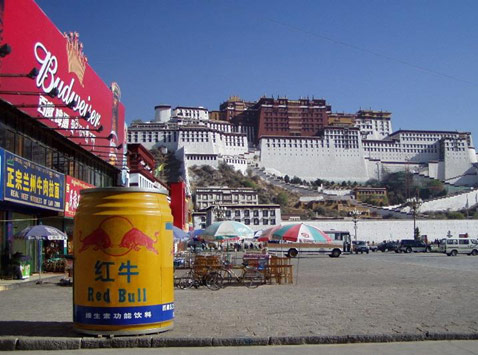 A large yellow barrel in front of a large buildingDescription automatically generated